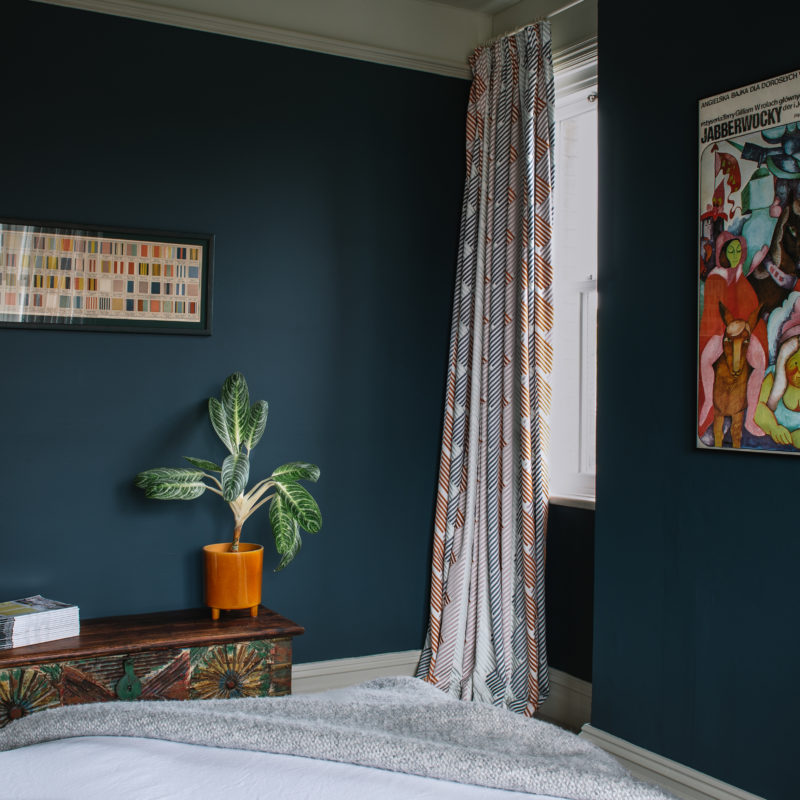 Dark blue bedroom with art